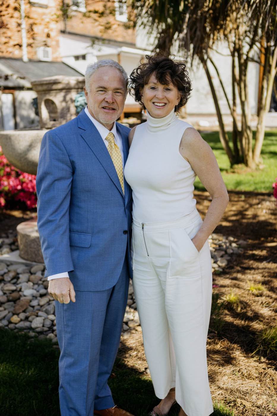 Smiling couple in a garden setting, natural light, joyful mood, vibrant colors.